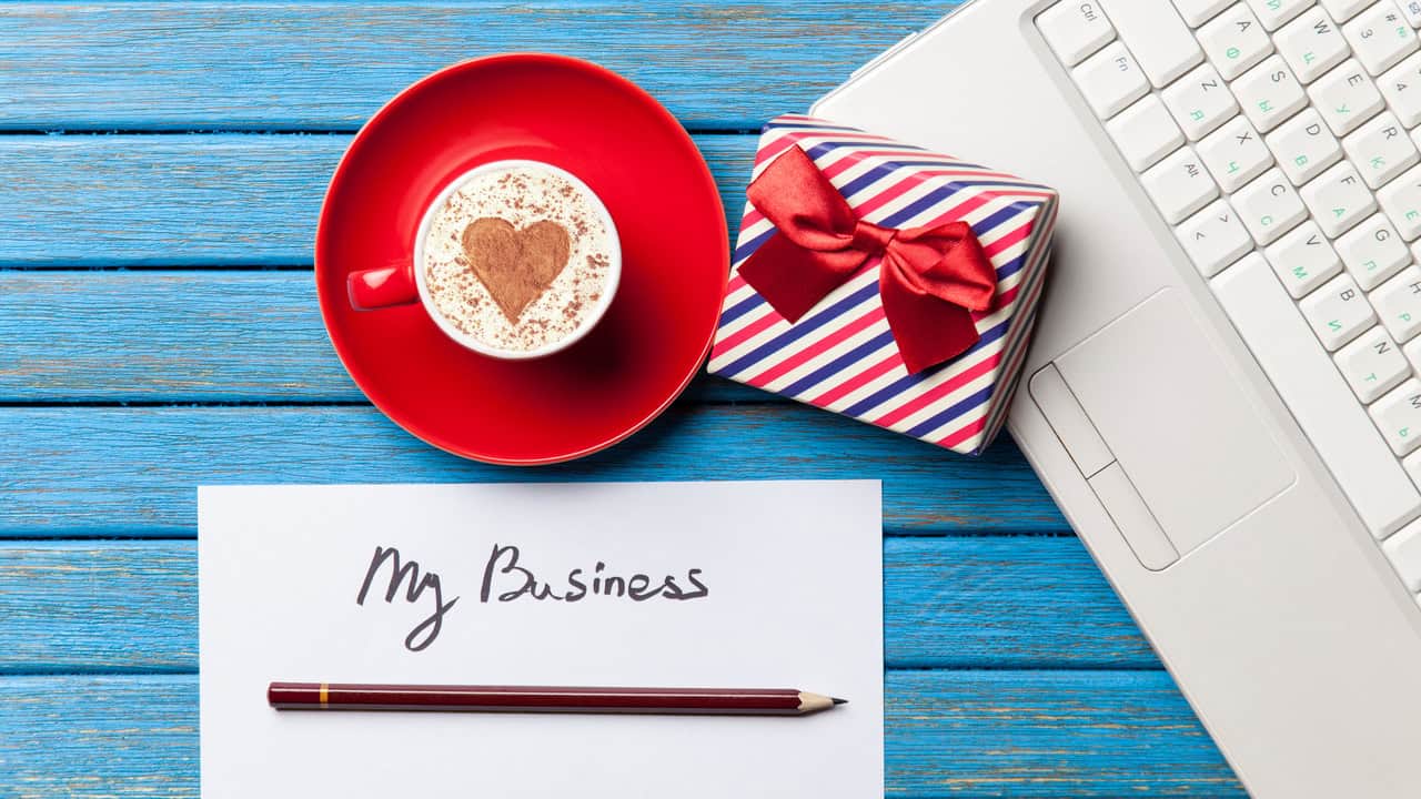 Paoer gift, coffee and laptop lying on a desk - Bayside Business of the Month -