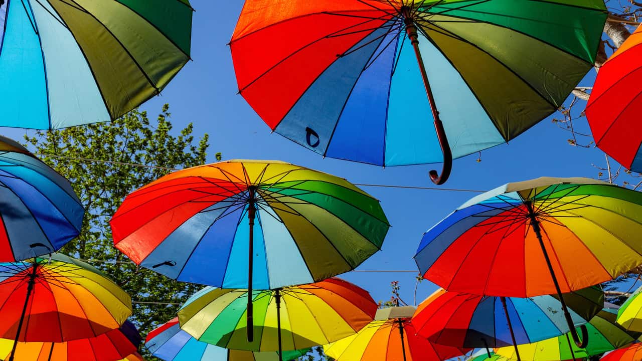 Colourful rainbow umbrellas with a blue sky background